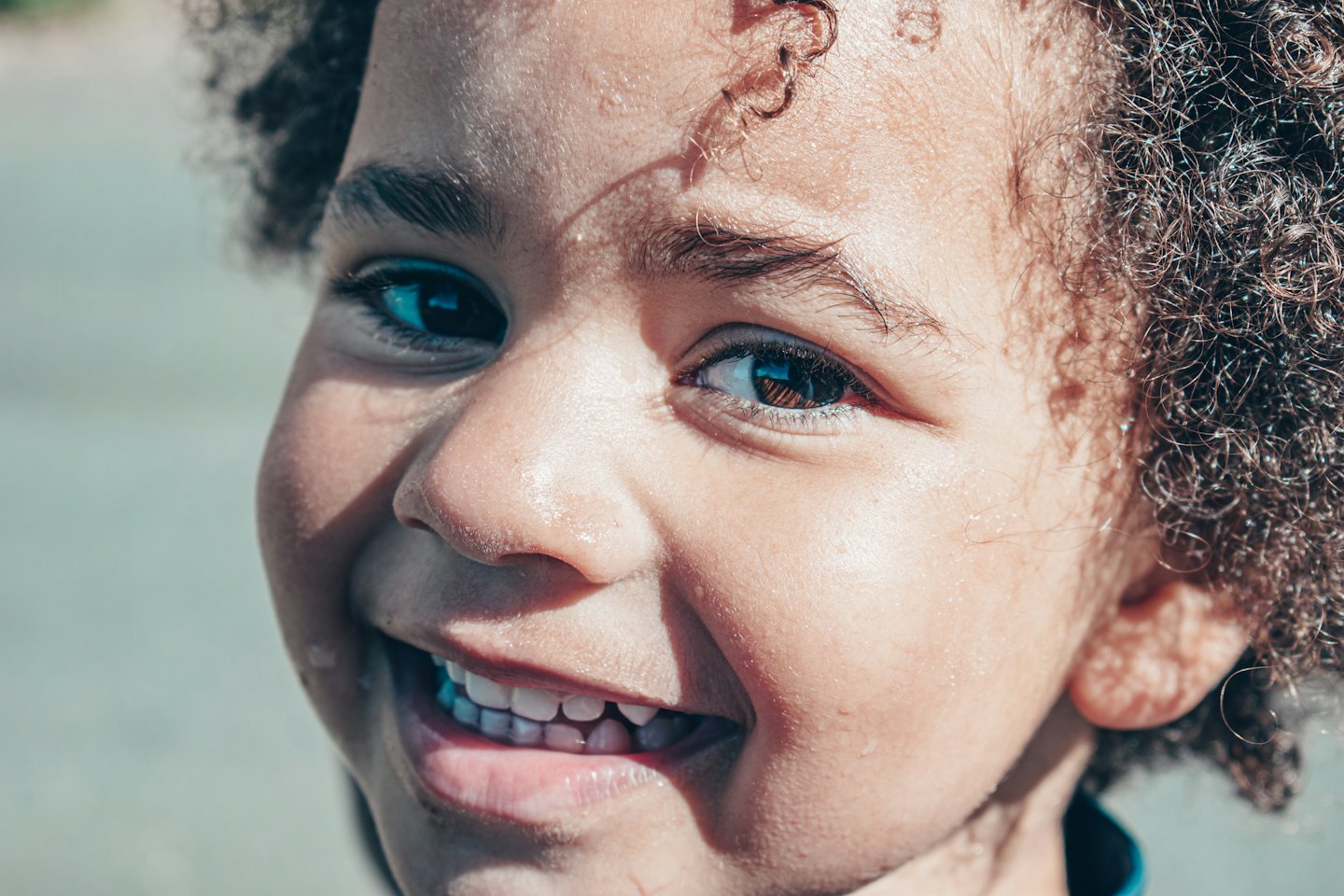Smiling child with curly hair looking at the camera.